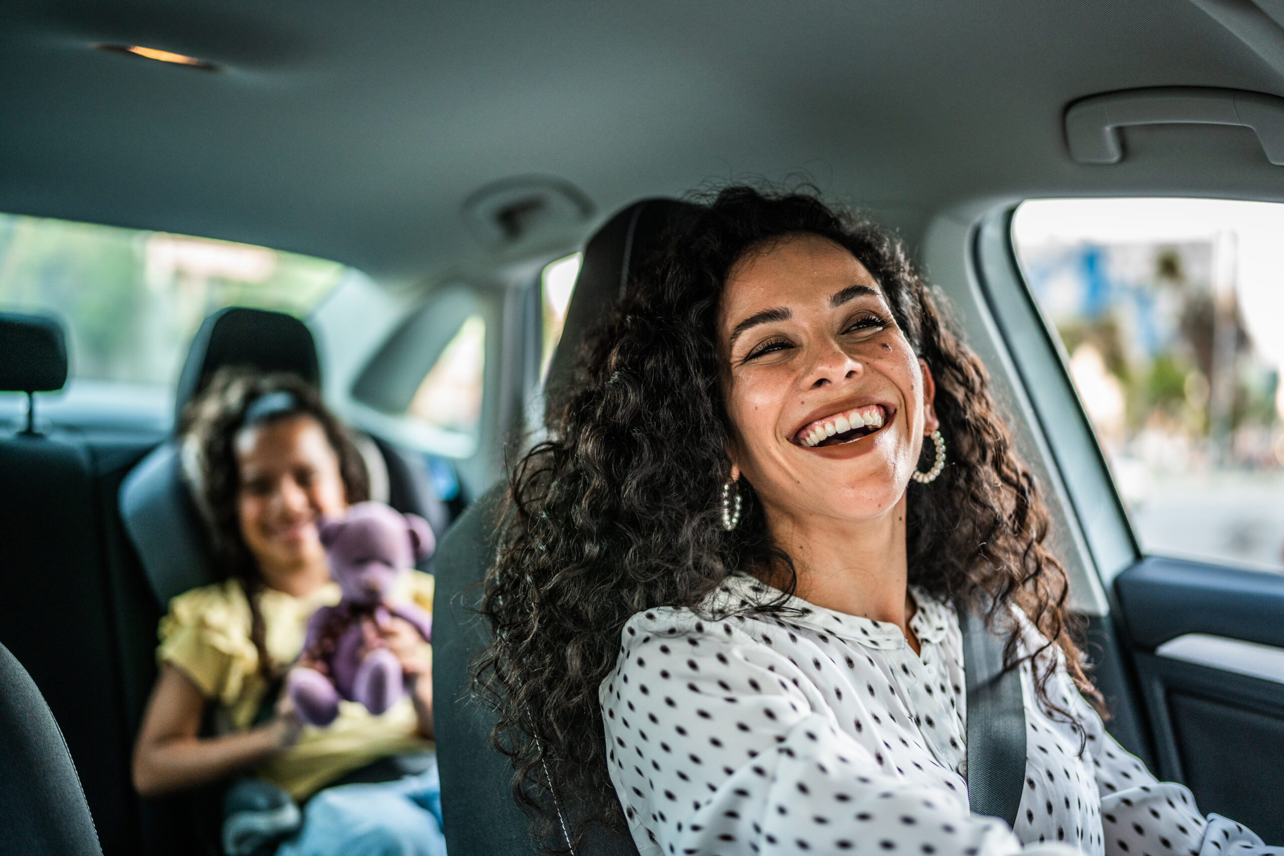 Mother and daughter talking at car