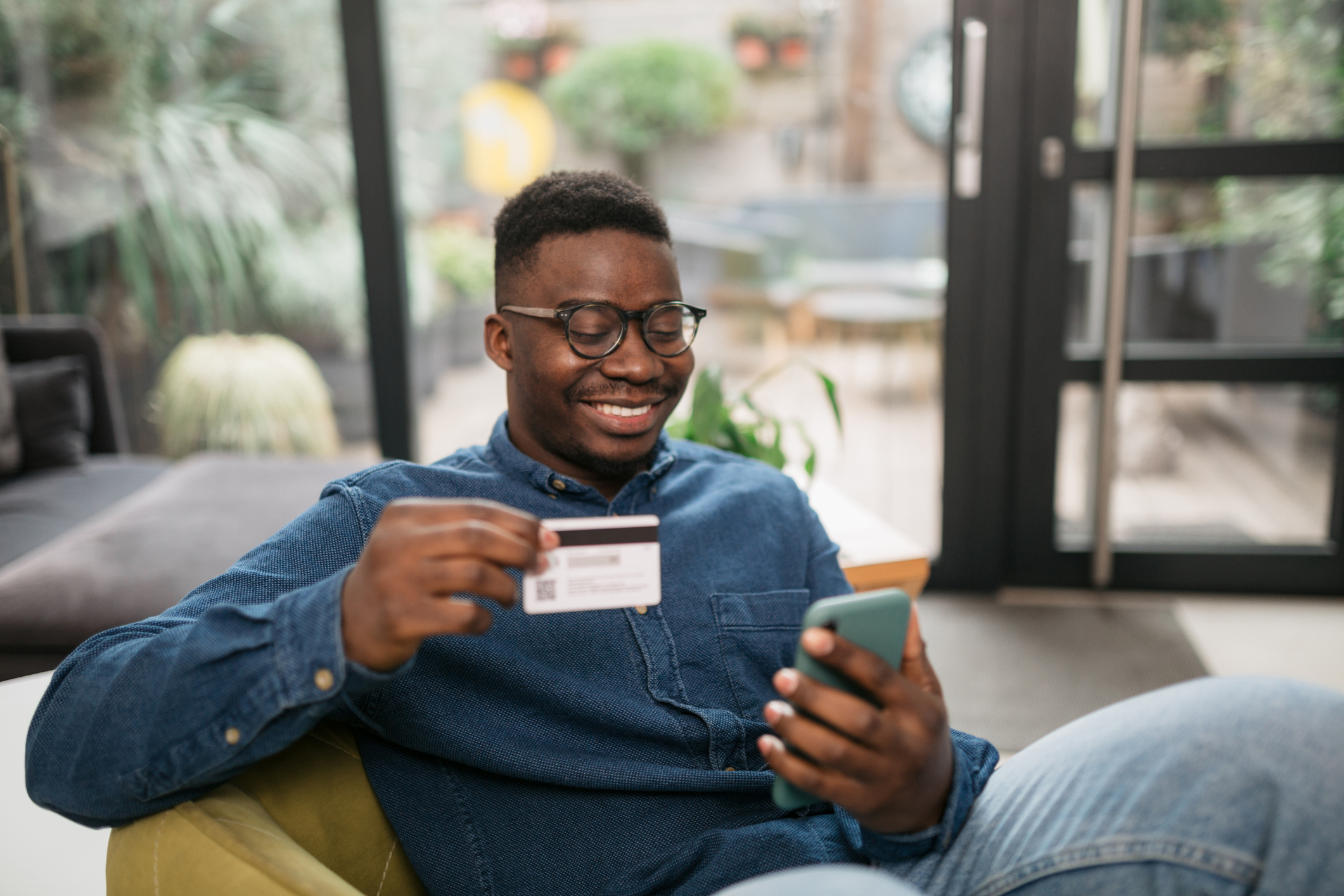 Happy young African American man shopping from home